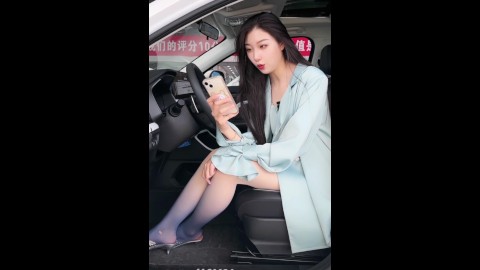 The beauty who wears black and white gradient color pantyhose and high-heeled sandals sells cars