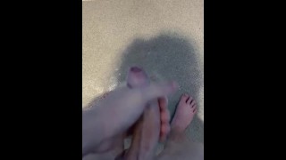 Masturbación gay joven en el gimnasio en pies de ducha