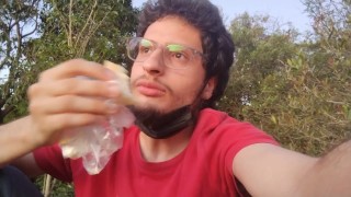 Мужчина ест хот-дог в общественном парке, фетиш 