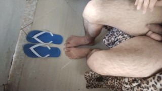 Jongen in blauwe sandal voedt zijn bulge buik met hete hondenvoet aanbidding