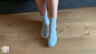 Chica sexy prueba sus nuevos calcetines deportivos blancos bonitos