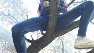 女の子が公共の場所の木の上でマンコをこする