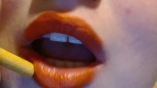 Fumer avec des lèvres orange et un sourire narquois