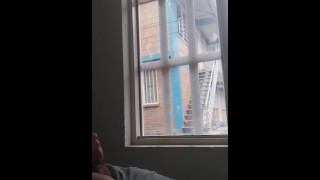 masturberen in het raam met uitzicht op de straat