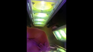 Heat from the tanning bed makes her hot and wetwet