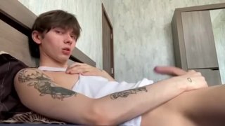 Cute twink jerks off his cock on the bed of his older brother and cums right on his shirt