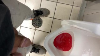 Rennen naar het toilet van het tankstation wanhopig pissed in urinoir en op de vloer kreunende verlichting