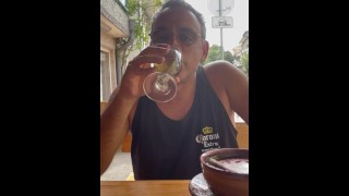 Pissen in een glas en drinken in het openbaar in een straatrestaurant