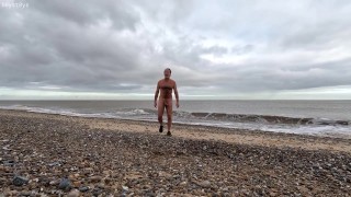 O naturista Naked na natureza. Winter a pé na praia.