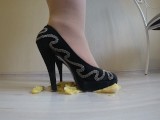She wears nylon tights, high heels and crushes a banana with her high heels.