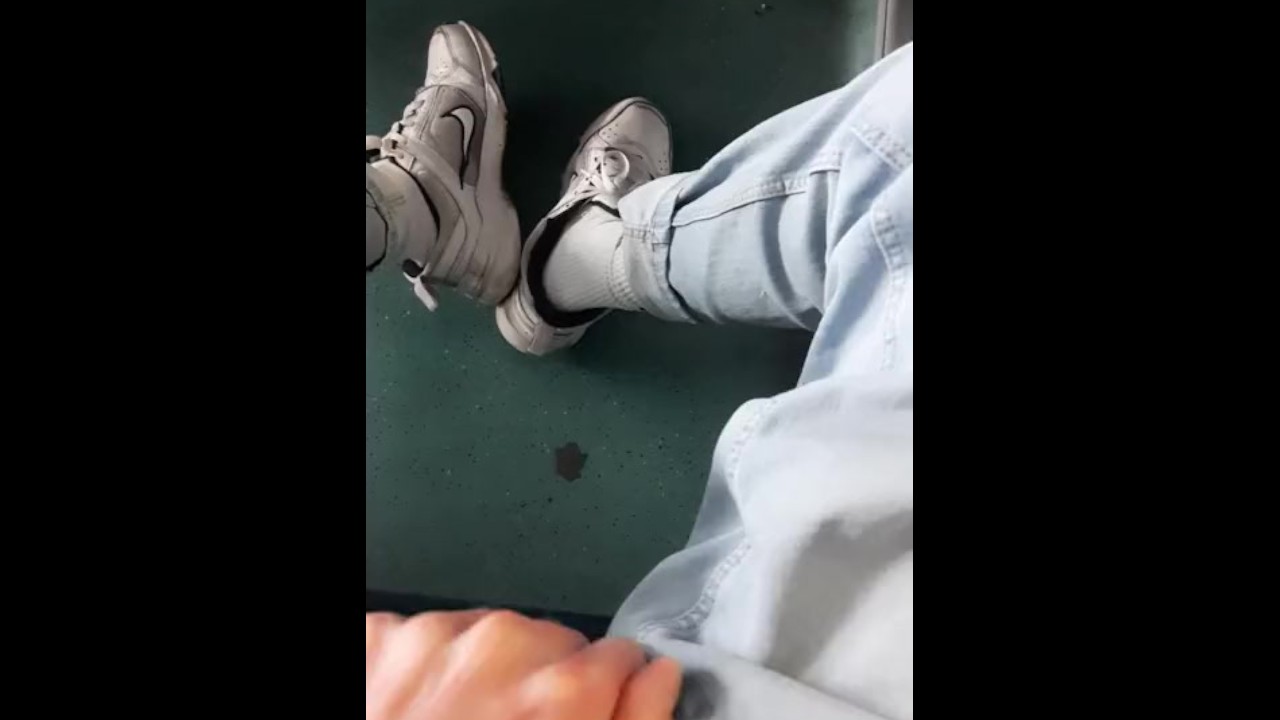 a young guy in blue jeans sneakers and white socks jerks off on an empty  train in Milan