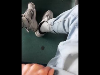 青いジーンズのスニーカーと白い靴下を履いた若い男は、milanで空の電車の中でけいれんします