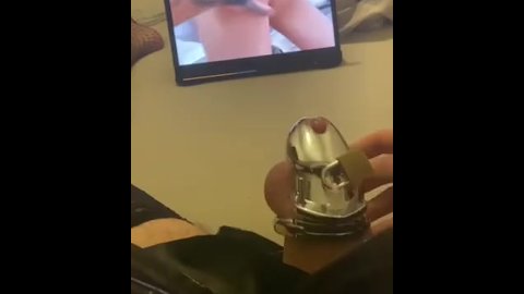 Sissy is watching porn and gets horny in chastity cage