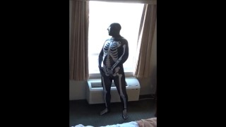 Skeleton trekt zich af bij het raam van het hotel terwijl vrachtwagenchauffeurs zich klaarmaken voor het werk
