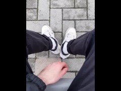 a guy in sneakers and white socks shows his feet at the train station