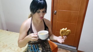 Sexy meisje drinkt plas in een kopje terwijl ze een Cookie eet