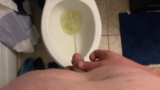 Mikropenis Molliger College-Student mit Pissen im Badezimmer des Studentenwohnheims