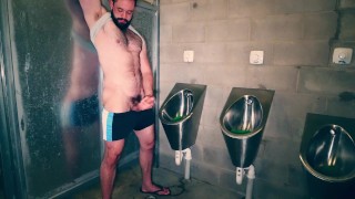 Furry muscle hunk shows off his big thick cock at the public urinal