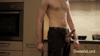Парень в штанах дрочит свой член на кухне