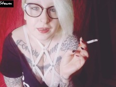 Blonde smokes a cigarette while staring at you