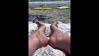 Relajándome en la playa con mis dedos de los pies en la arena
