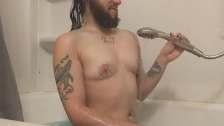 Homme trans se branle avec une pomme de douche
