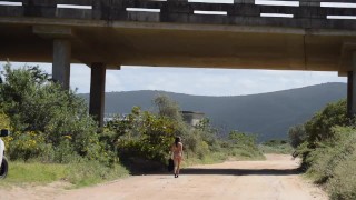Caminando Naked en carretera abierta bajo un puente