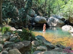 VOYEUR ON A GIRL BATHING IN A SUNNY STREAM