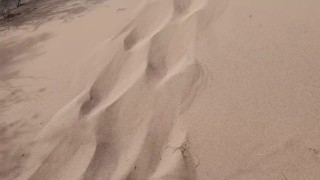 屋外の砂漠の真ん中にいるツアーガイドは、公共の場で開いたマンコで砂の上におしっこをしているのを見られています