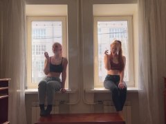 Two girls are smoking on the window