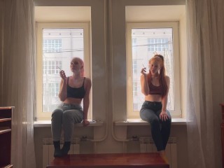 2人の女の子が窓の上で喫煙しています