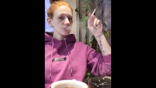 Ruiva fuma em um café