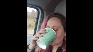 girlfriend drinks a big cup of very yellow piss in car.