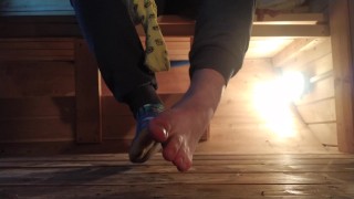 Garoto de meias coloridas sujas depois de um dia na sauna e tirando as meias para os pés descalços
