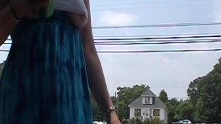 MILF braless wearing a cut off crop top revealing underboob near roadside with traffic