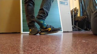 Ноги мальчика-твинка в разноцветных носках в школе