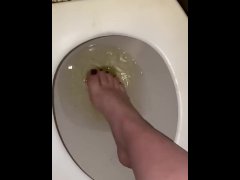 Perverted bitch wets feet in her piss in the toilet