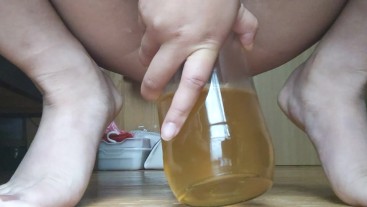 ガラス瓶に約500mlの黄色いおしっこをする日本人女性