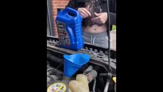Девушка заправляет масло в машину и светит сиськами