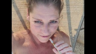 Milf nuda fuma al di fuori della piscina e gioca con la figa