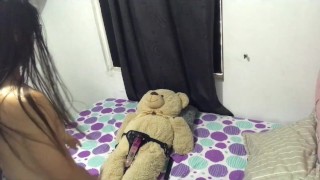 Une lesbienne chevauche l'ours en peluche avec un harnais.