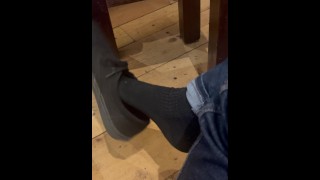 Shoeplay and dangling in vans and black socks in the coffee shop