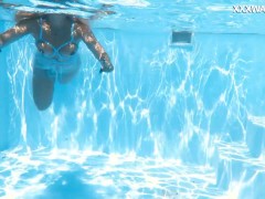A woman floats in a butterfly-adorned mesh dress