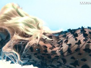 A woman floats in a butterfly-adorned mesh dress