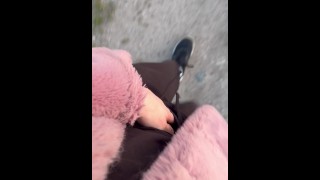 ピンクの毛皮のコートを着て自然を歩く