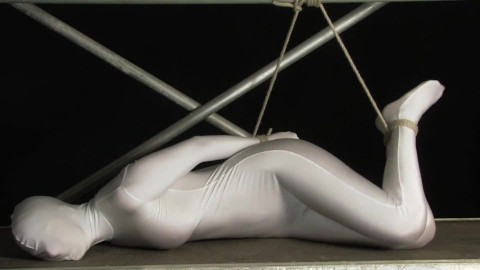 Babe wrapped in white zentai suit enjoys to be bondaged to a metal pole