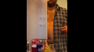 Hongerige mollige jongen controleert koelkast