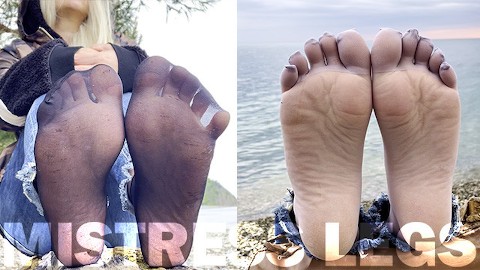 Pieds taquiner en chaussettes en nylon noir et gris remuer les orteils au bord de la mer