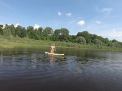 Нудистка на САП борде на большой реке