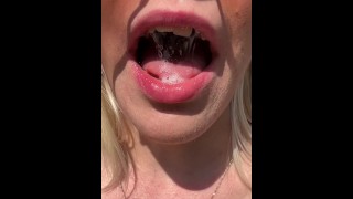 Uma boa garota está mostrando sua língua esfumaçada e molhada na boca e uvula